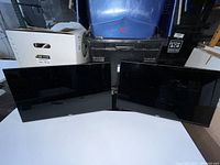 Two black Dell 24-inch monitors side by side, screens off, no stands visible