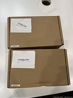 Two unopened and sealed brown cardboard boxes containing the Lenovo ThinkPad docking stations.