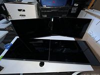 Four Dell 24-inch flat screen monitors arranged in two rows on a table, showing front screens facing forward, no stands visible.