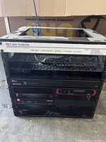 Front view of the AV rack with McCann Systems label on the top frame and multiple rack-mounted devices visible including Crestron and JBL equipment.