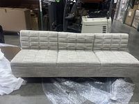Front-left angle view of sofa in warehouse setting