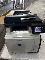 Full view of HP LaserJet Pro MFP printer showing automatic document feeder and color touchscreen panel.