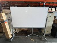 Front view of the rolling marker board showing entire whiteboard surface and metal frame with wheels.