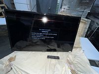 Front view of Samsung 40 inch LED TV powered on showing 'No Cable Connected' message with remote on cloth below.