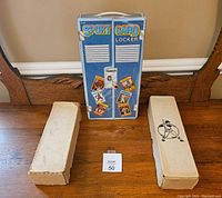 Blue metal-style sport card locker with decals of baseball cards and two rectangular cardboard boxes on a wooden surface.