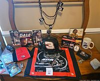 Complete lot overview showing apparel, models, collectibles, and books on a table in front of a mirror