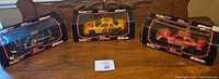Lot of three NASCAR diecast cars in original packaging on a wood table