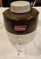 Front view showing brown body, white spout, and Coleman logo