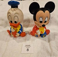 Front view of Donald Duck and Mickey Mouse vintage squeaky toys on white towel background, numbered 8