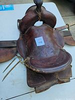 Full top view of the vintage brown leather horse saddle showing the seat, saddle horn, and side skirts with tooling.
