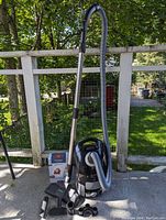 Assembled vacuum with hose, wand, floor tool, attachments and adapter rings arranged outdoors