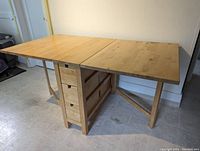 Table fully extended from front-left angle showing top surface and drawers