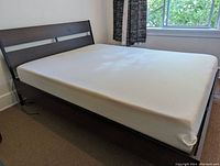 Assembled bed frame with mattress in room