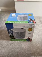 View of the sealed box showing front with product image, brand name, and room coverage size.