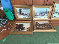 Four framed Cornelius Krieghoff style prints displayed together including winter and autumn rural scenes, their frames are gold-toned with detailed edges.