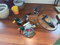 Photo showing wooden duck plaques, gumball machine, phone handset, and assorted flower pots on the floor.