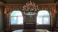 Pair of Ethan Allen floral patterned curtains with valances on arched windows viewed straight on