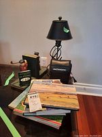 Metal base table lamp with black twisted metal stand, black lampshade with brass details.