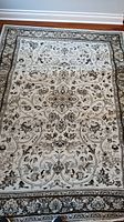 Full front view of Ornate Beige and Brown Floral Design Carpet Art Deco rug on hardwood floor.