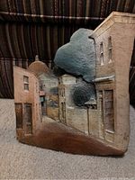 Front view of signed village scene ceramic relief tile