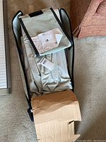 Cot folded inside carrying bag with instruction sheet on top