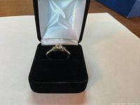 Ring displayed upright in a black velvet box showing overall appearance and setting