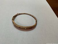 Front view of closed bracelet showing central old mine cut diamond flanked by two cushion cut rubies