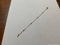 Full length view of 7" yellow gold bracelet on white background