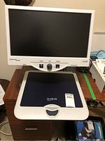 Front view of Merlin Ultra video magnifier showing control panel, LCD screen and flatbed reading table