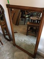 Front view of the wood framed wall mirror showing the entire frame and reflective glass surface.