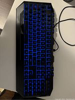 Front view of the CM Storm RGB gaming keyboard showing blue LED illuminated keys and black frame.