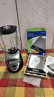 GE blender and Taylor digital scale shown together with scale box and manual
