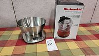 KitchenAid food chopper in its original box placed next to the digital kitchen scale with the stainless steel bowl visible.