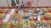 Multiple cookie cutter sets displayed on a checked tablecloth including Christmas, heart, flower, and animal shapes.