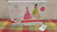 Photo of the back of the box showing pink and green princess cake models and baking set contents.