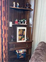 Wide view of shelf showing various figurines, snow globes, boxed German Clown Bear, and other collectibles.