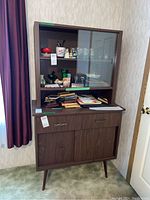 Front view of the entire two-tier wooden retro cabinet with glass sliding doors on top and drawers and sliding doors below.