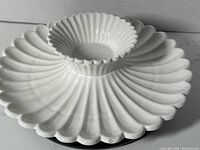 Top-down view showing scalloped white ceramic petals radiating from central dip bowl.