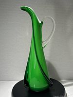 Full view of green Empoli art glass carafe with clear handle against white background