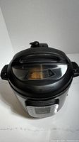 Closed Instant Pot Duo 6qt electric pressure cooker showing lid and digital control panel.