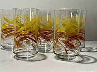 Set of six Libbey Golden Harvest Wheat drink glasses arranged in a cluster showing detailed wheat design and size