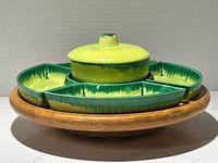 Front angled view of the Mid-Century Atomic California Pottery Lazy Susan set showing the lidded center pot and curved serving dishes on oak base.