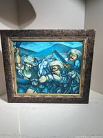 Full view of the framed oil painting showing four figures with turbans in a blue mountainous landscape.