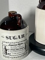 Close-up of Sugar canister showing glossy brown lid, cork stopper, and vintage style printed label.