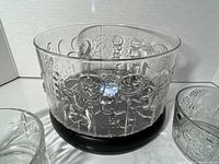 Photo showing the large clear glass serving bowl with floral pattern, along with one small bowl partially visible, overall view of the set