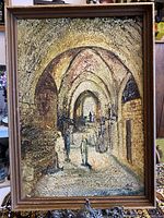 Full front view of framed oil painting showing textured street scene under arches with multiple figures, signed by Andre Elbaz.