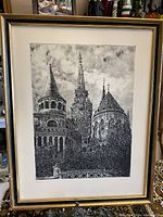 Framed vintage black and white etching depicting an iconic castle with detailed architectural elements including spires and turrets under a cloudy sky.