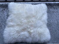 Front view of white, handmade fur pillow showing texture and softness