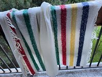 Couch throw blanket hanging showing full stripes and fringed edge.