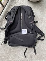 Back view of black ObusForme backpack showing ergonomic padded back panel, comfort support system label, adjustable padded shoulder straps, and clip buckles.